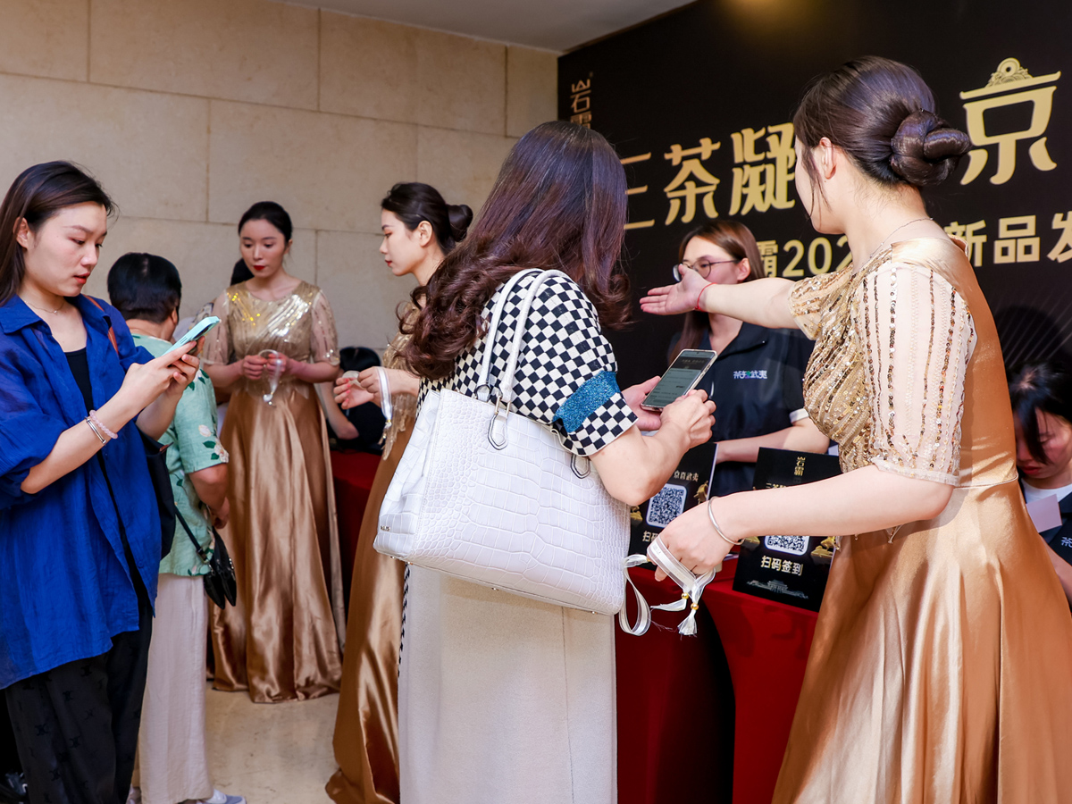 會務(wù)禮儀人員引導(dǎo)參會者入場簽到